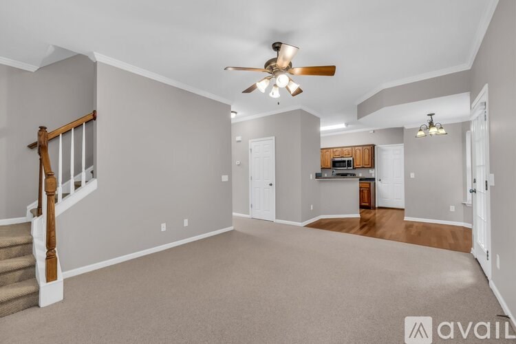 A spacious living room with a staircase on the left side.