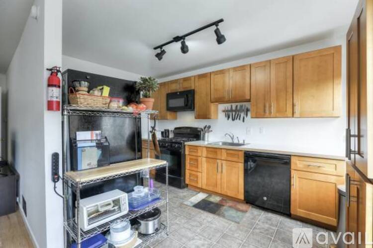 A kitchen with wooden cabinets and a black countertop.