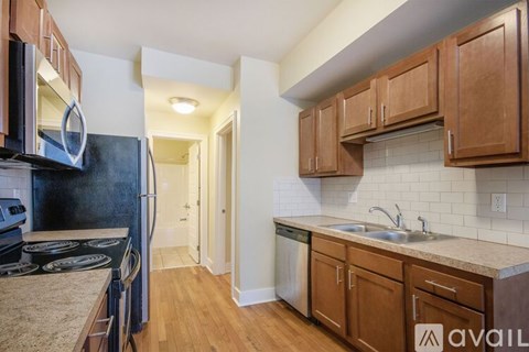 A kitchen with wooden cabinets and a black refrigerator.
