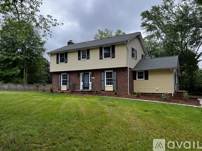 A house with a beige siding and a brick chimney is for sale.
