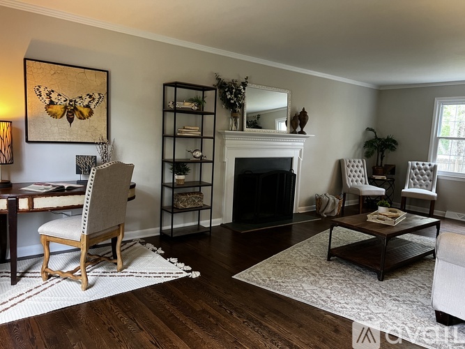 A living room with a fireplace, a chair, and a painting.