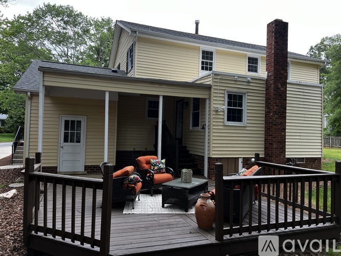 A house with a porch and a person sitting on it.