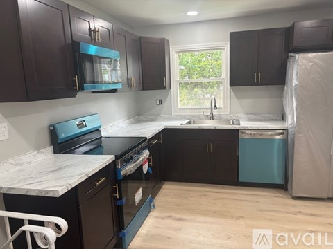 A kitchen with dark brown cabinets and a white countertop.