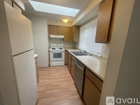 A kitchen with wooden floors and white appliances.