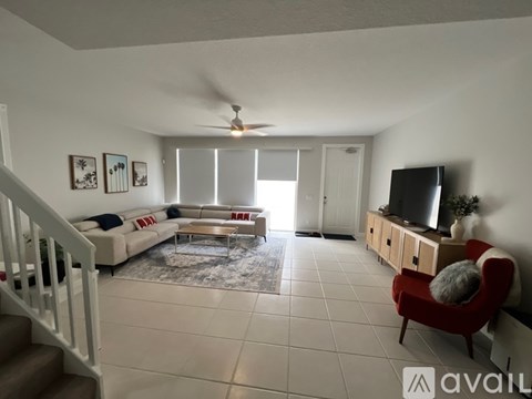 A living room with a red chair and a television.