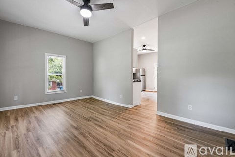 A room with wooden flooring and a ceiling fan.