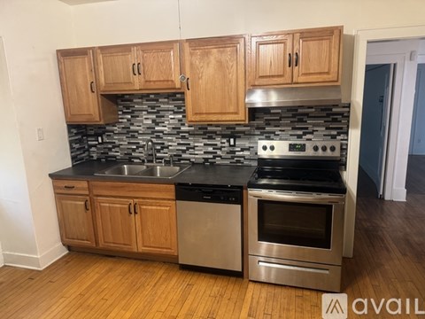 A kitchen with wooden cabinets and a black countertop.