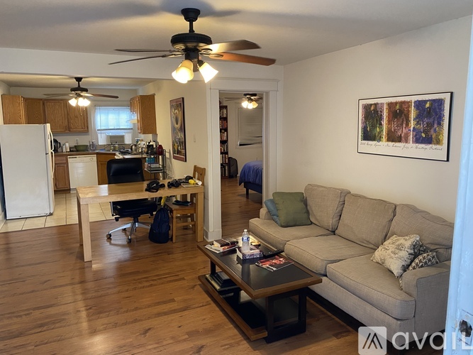 A living room with a couch, a coffee table, and a ceiling fan.