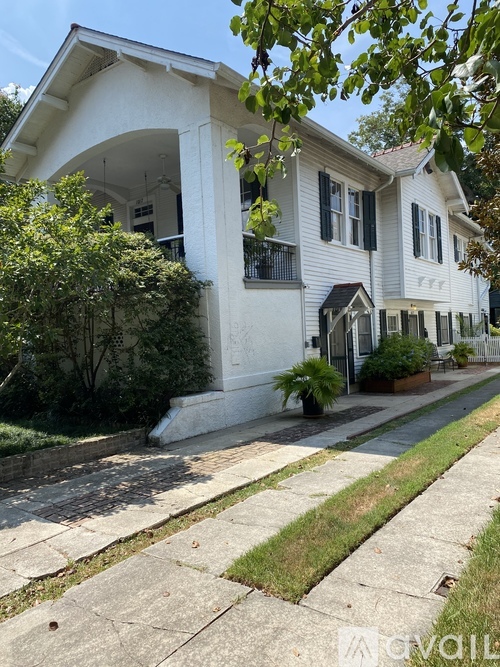 A white two-story house with a balcony on the second floor.