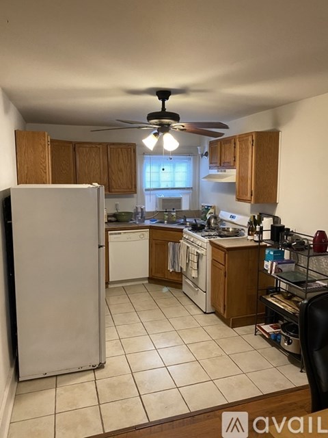 A kitchen with a white refrigerator and wooden cabinets.