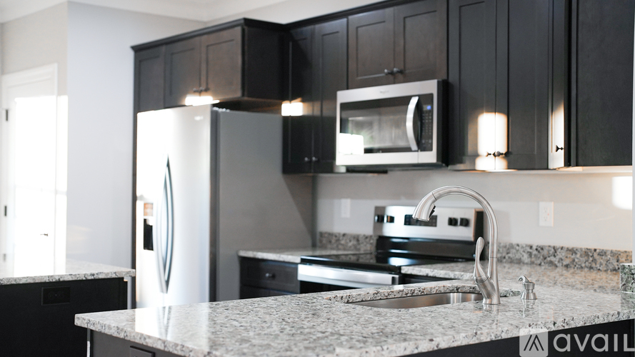 A kitchen with black cabinets and a granite countertop.