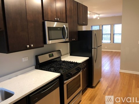 A kitchen with black cabinets and a black refrigerator.