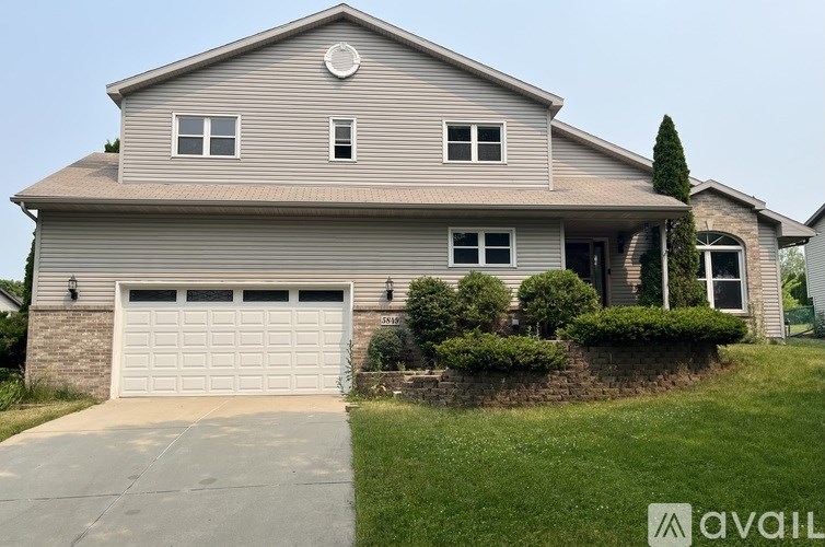 A house with a grey roof and a white garage door.