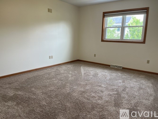 A room with a carpeted floor and a window.