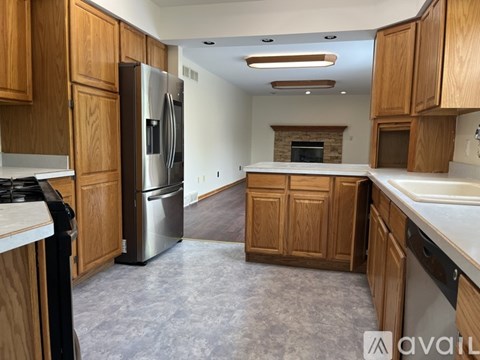 A kitchen with wooden cabinets and a refrigerator.