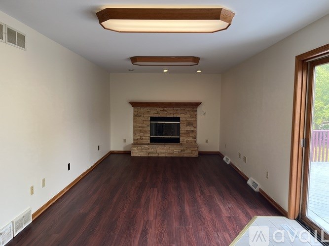 A living room with a fireplace and wood flooring.