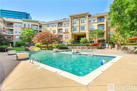 A large swimming pool in front of a multi-story apartment building.