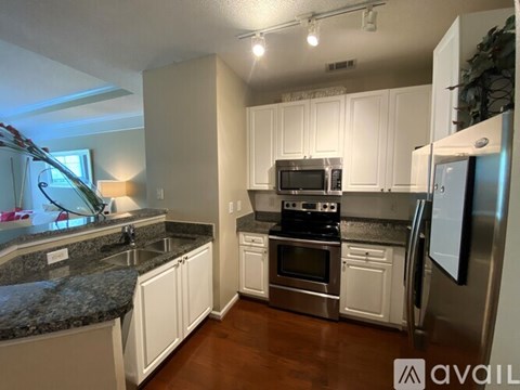 A kitchen with white cabinets and a granite countertop.