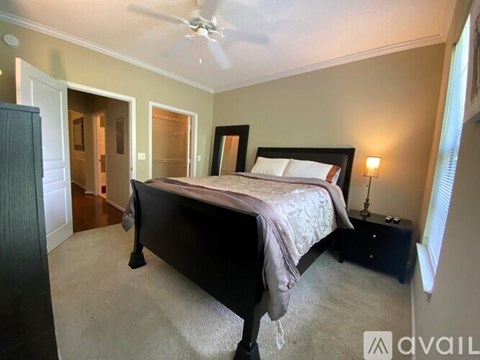 A bedroom with a bed, dresser, and mirror.