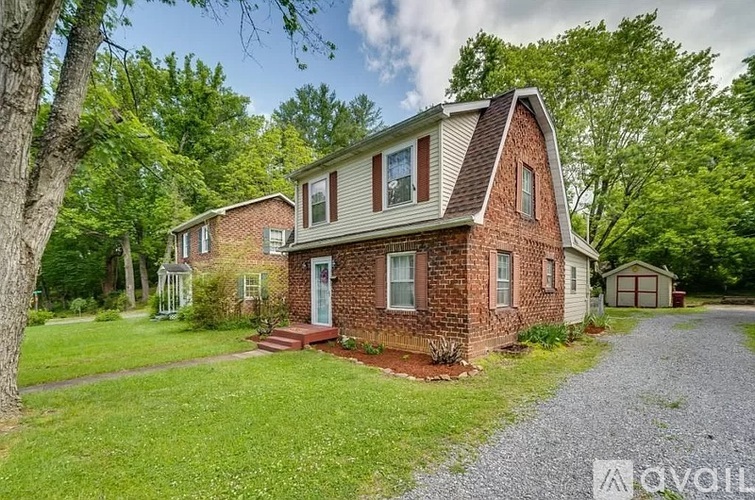 A house with a gravel driveway in front of it.