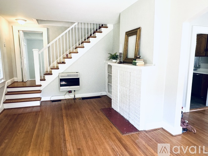 A white staircase with a wooden floor and a white wall.
