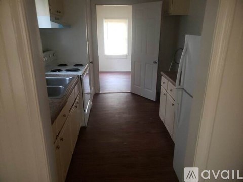 A kitchen with white cabinets and a stove top oven.