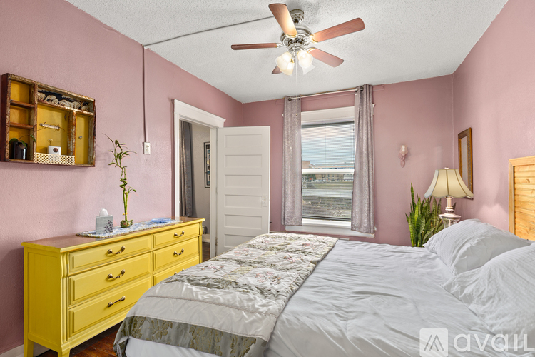 A bedroom with a bed, dresser, and window.