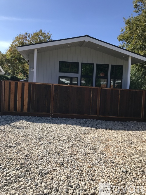 A house with a white exterior and a brown fence.