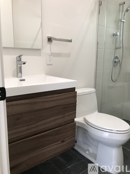 A white toilet sits next to a white sink in a bathroom.