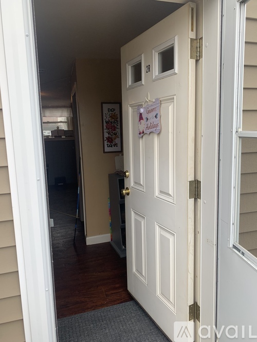 A white door with a sign on it is open.