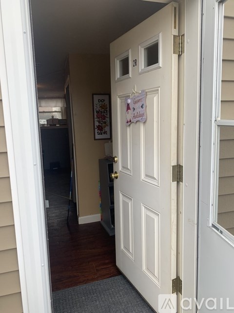 A white door with a sign on it is open.