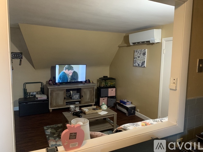 A living room with a television on a wooden stand and a couch.