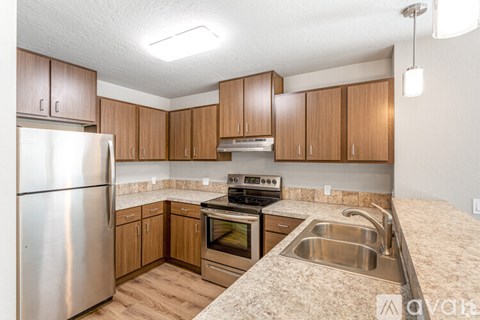 A kitchen with wooden cabinets and stainless steel appliances.