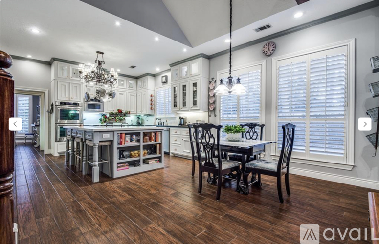 A kitchen with a dining table and chairs.