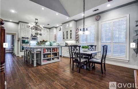 A kitchen with a dining table and chairs.