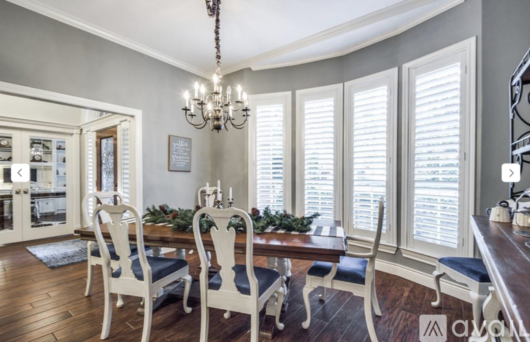 A dining room with a wooden table and chairs.