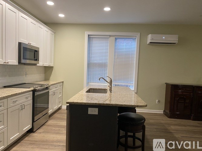 A kitchen with a granite countertop and white cabinets.