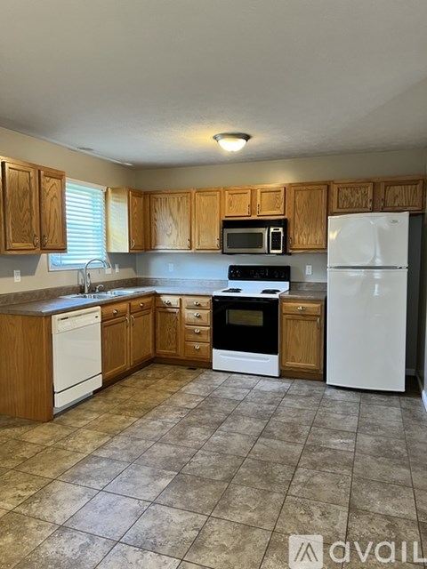 A kitchen with wooden cabinets and white appliances.