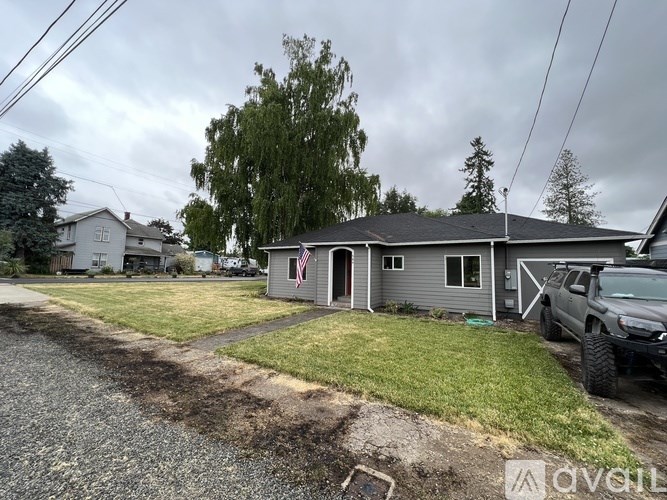 A house with a gray roof and a gray car parked in front.