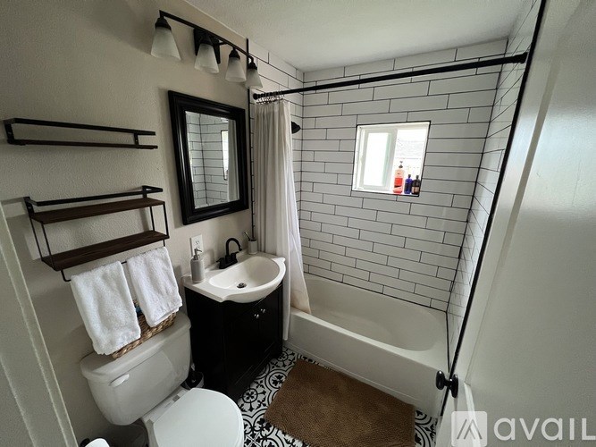 A bathroom with a toilet, sink, and a shower.