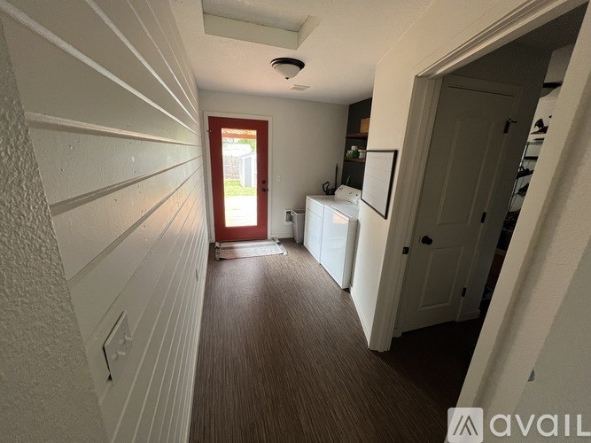 A hallway with a red door at the end.