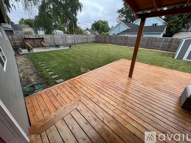 A wooden deck with a hose on the ground.