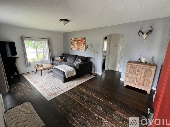 A living room with a grey couch and a wooden coffee table.
