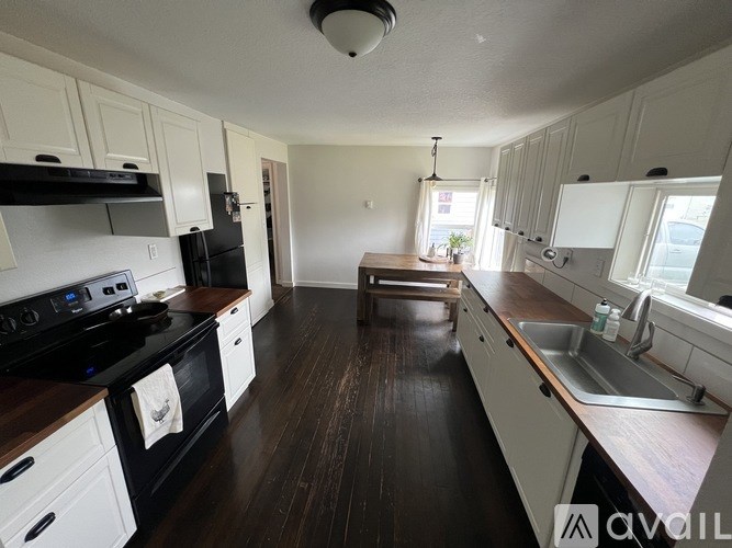 A kitchen with black stove top and white cabinets.