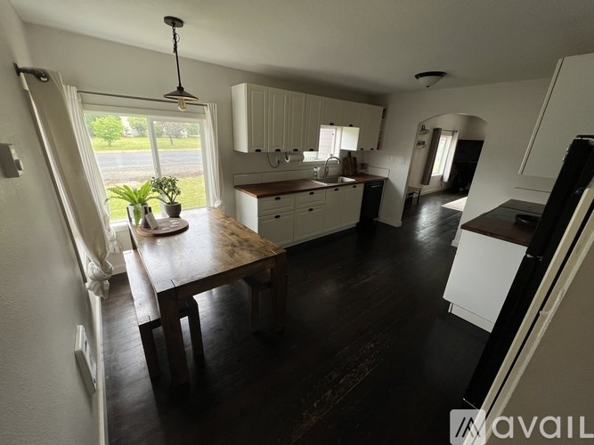 A kitchen with a table and chairs in front of a window.