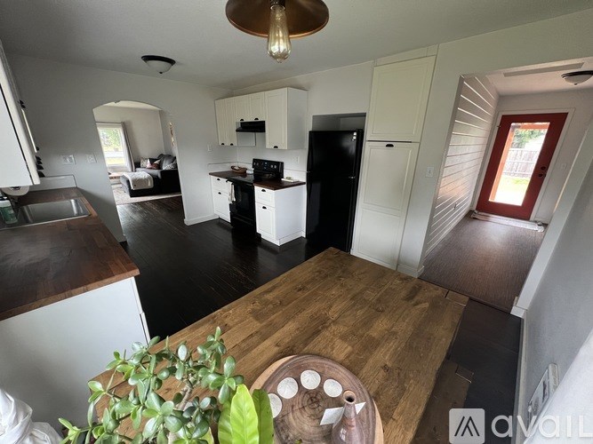 A kitchen with a wooden table and a plant on it.