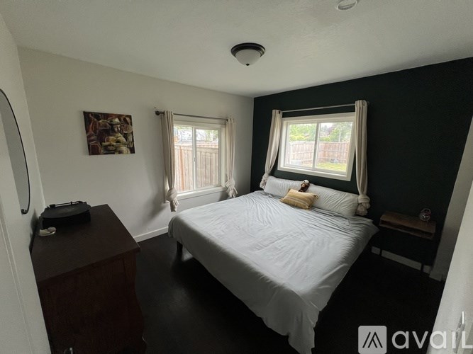 A bedroom with a bed, nightstand, and window.
