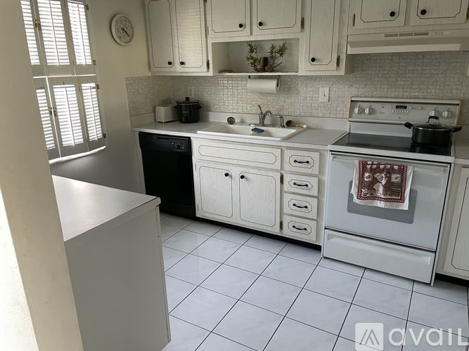 A kitchen with white cabinets and appliances.