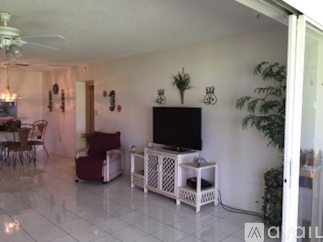 A living room with a television and a dining table.