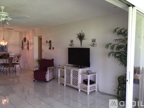 A living room with a television and a dining table.